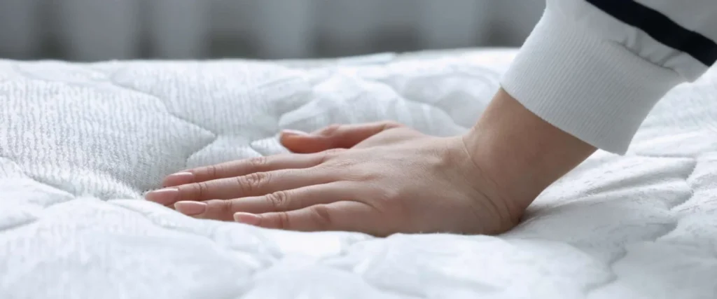 Plush mattresses explained: How to choose the right comfort level for your sleep profile 3 Hand pressing into plush mattress
